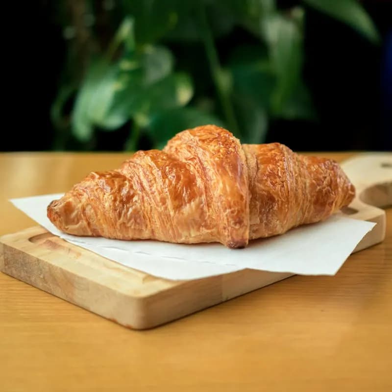 Croissant pur beurre doré sur une planche